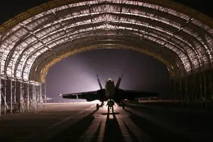 Jet aircraft in a hangar at night
